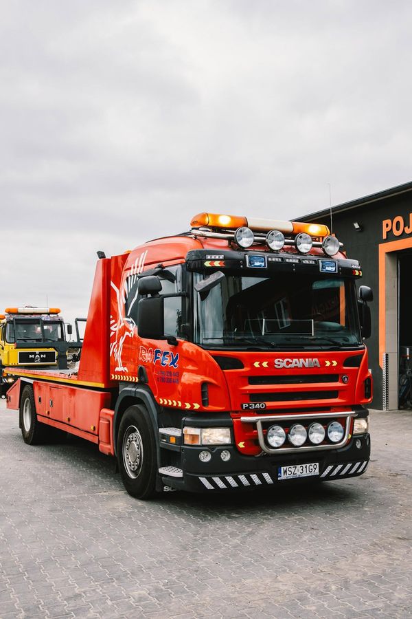 Laweta Scania pomocy drogowej RAFEX przed warsztatem